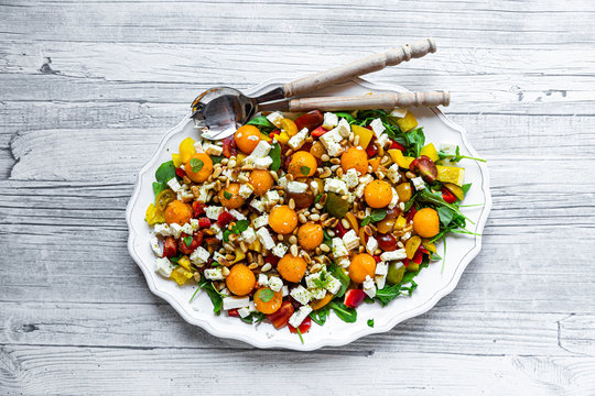 High angle view of healthy salad with spoons in plate on wooden table