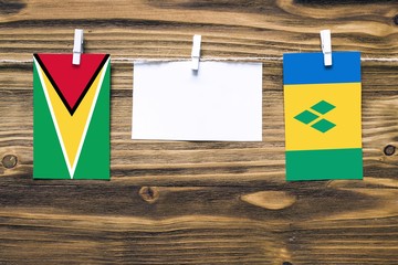 Hanging flags of Guyana and Saint Vincent And The Grenadines attached to rope with clothes pins...