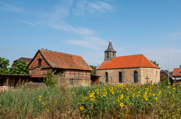 Alte Kirche mit Sonnenblumenfeld im Vordergrund