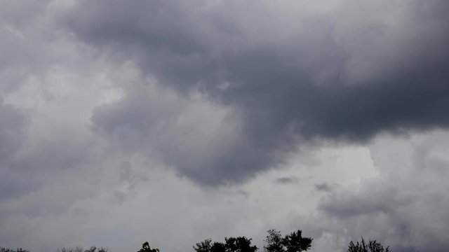 Time lapse of dark rolling clouds giving way to blue sky at end