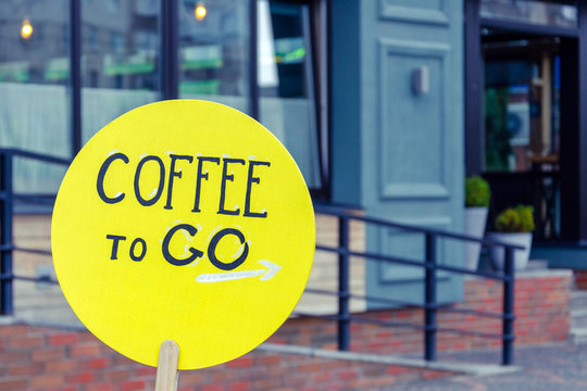 inscription coffee to go on a yellow round plaque on the street. coffee slogan for advertising. coffee concept