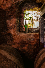 Botella en la ventanilla de la bodega con telarañas.