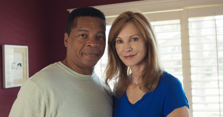 Fototapeta premium Happy smiling senior couple looking at each other then turning to face camera