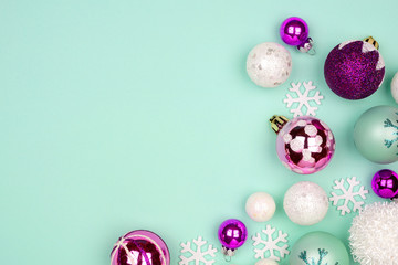 Modern pastel Christmas bauble corner border over a turquoise background with copy space