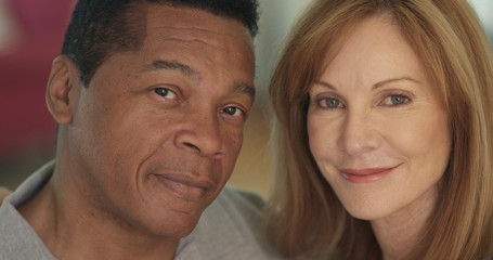 Close up portrait of smiling mixed race senior couple looking at camera