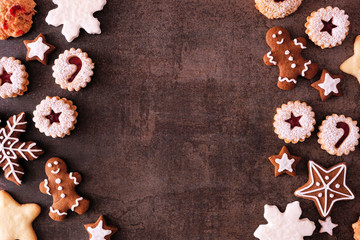 Variety of Christmas cookies and sweets. Top view double side border over a dark stone background with copy space. Holiday baking concept.