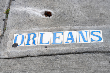 Historic old town Orleans street sign on sidewalk pavement in New Orleans, Louisiana famous town city during day flat top view down