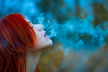 girl blows smoke out of her mouth