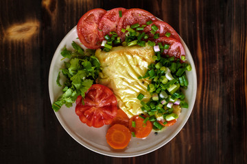 baked fish with cheese and vegetables, tomatoes, coriander and fish. Presentation of the finished dish in the restaurant on the table top view.