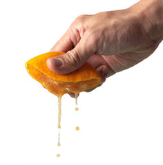 Fototapeta na wymiar Hand squeeze orange slice with orange juice on white background