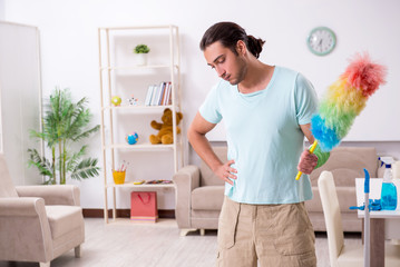 Young injured man cleaning the house