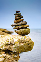 Pyramid of sea pebbles on a background of the sea.