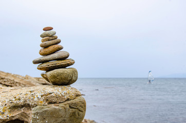 Pyramid of sea pebbles on a background of the sea.