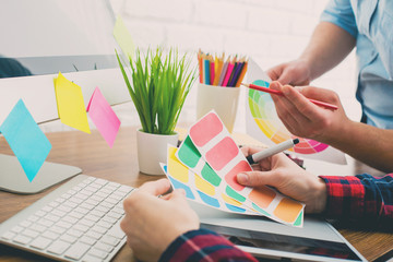 Your young designer discussing ideas and smiling while working in office