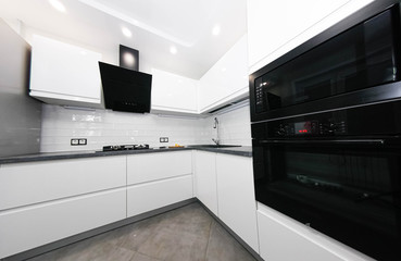 interior of a small modern white kitchen with built-in appliances.