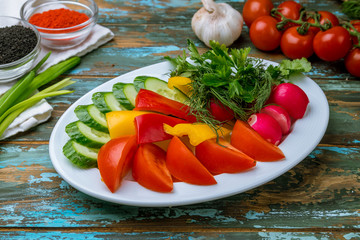 slicing fresh vegetables on a plate on wooden table