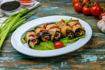 Eggplant rolls stuffed with nuts on wooden table