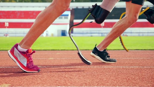 Close up of healthy and prosthetic legs while running