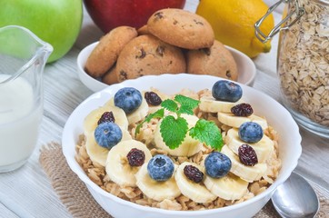 Delicious sweet healthy breakfast. Oatmeal with bananas, blueberries and cranberry.