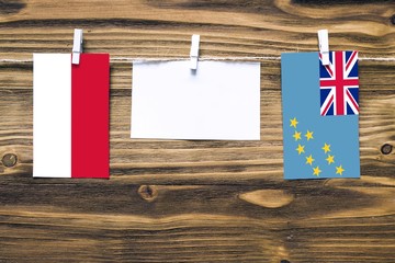 Hanging flags of Indonesia and Tuvalu attached to rope with clothes pins with copy space on white...