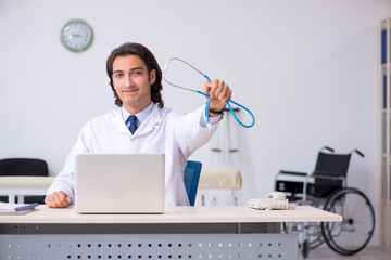 Young handsome doctor cardiologist working in the clinic