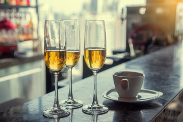 Three white wine cups and coffee cups Put on the counter at the hotel at the party.