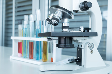 Microscope with sample test tubes on the table laboratory