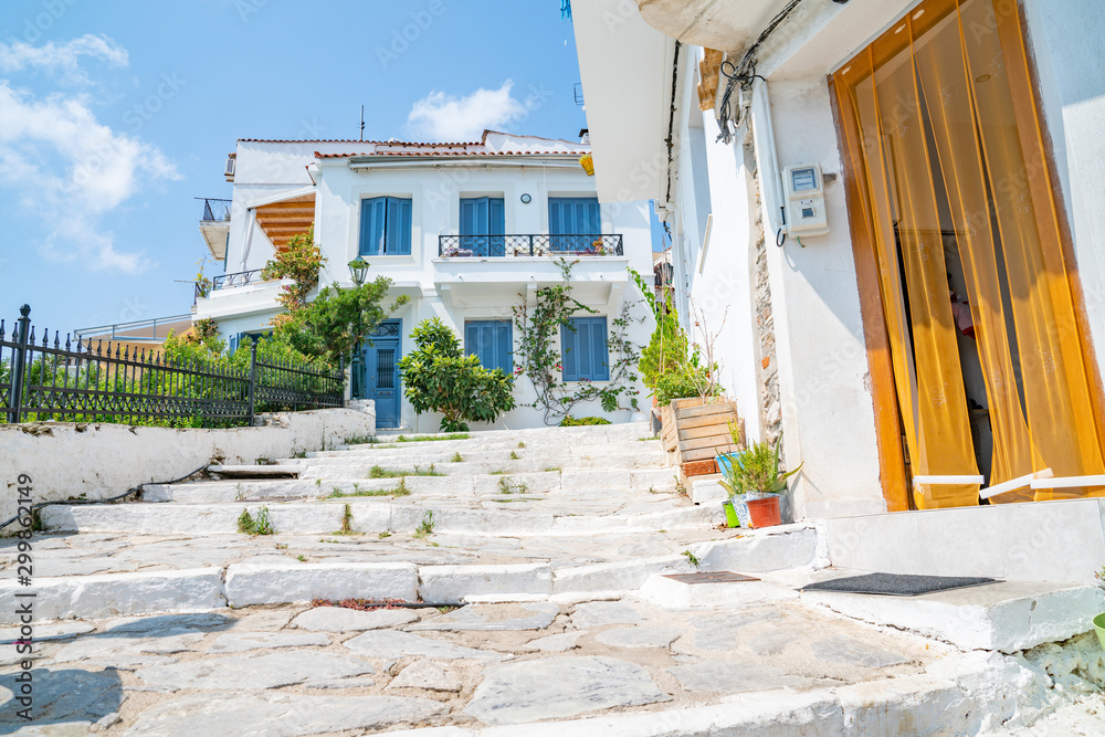 Sticker Steps up to and past entrances of whitewahsed walls and typical Mediterranean blue doors and window shutters