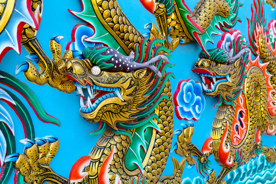 Golden Dragon statue on wall at temple in Thailand,chinese Style