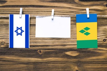 Hanging flags of Israel and Saint Vincent And The Grenadines attached to rope with clothes pins...