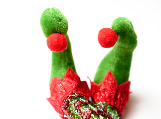 Adorable plush elf feet wearing red white and green pointy shoes with pom poms and glittered...