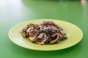 crispy fried fish skin on green dish