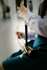 Girl student is playing thai music instrument,treble fiddle,violon soprano