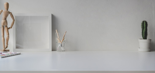Minimal office room with copy space and decorations on white wooden table