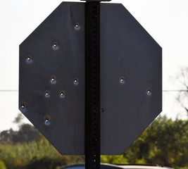 back of stop sign all shot up