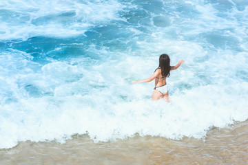 Background with a happy teenage girl splashing in the sea foam
