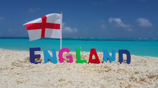 ENGLAND country name written with 3d wooden letters and the flag fluttering on the wind on white sand tropical beach