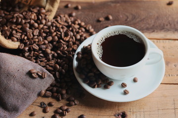 cup of coffee and beans on wooden table
