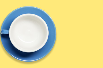 Empty blue cup on a yellow background