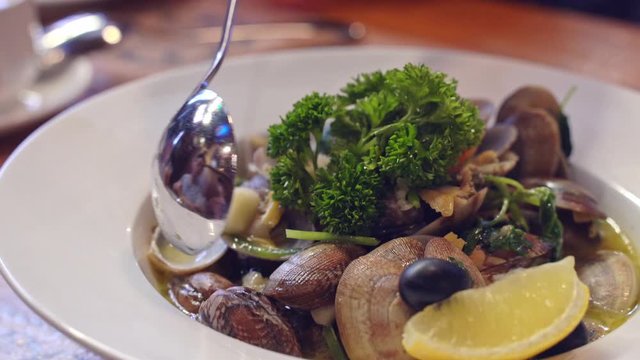 Family is eating, enjoying delicious Baked assorted vegetables, stir-fried clams, fried cod fish ball in Macau Portuguese restaurant, lifestyle.