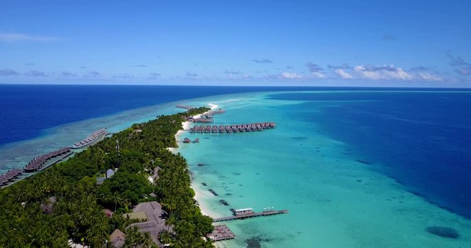 Tropical island on Rasdu Atoll, Kuramathi, with luxury resorts and beautiful white sand beaches in turquoise sea water. Wooden pier with moored boats