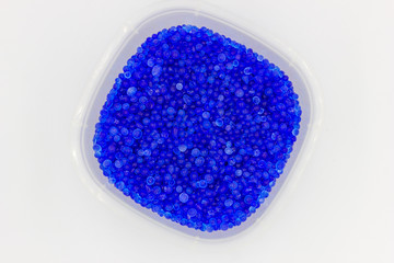 Blue silica gel adsorbs moisture from the air, preventing damage.