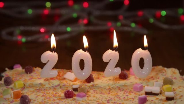 New Year 2020 burning candles on celebration cake