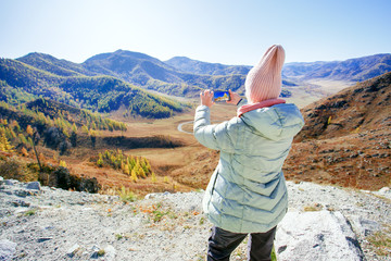 Female tourist capturing the landscape in her mobile phone on holiday.
