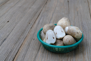 Straw mushroom in plastic basket on wooden table