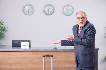 Old businessman at the hotel reception