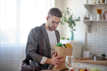 Businessman coming back home with bag of foods