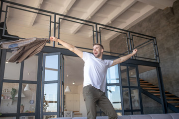 Man dancing while feeling happy coming to his new flat