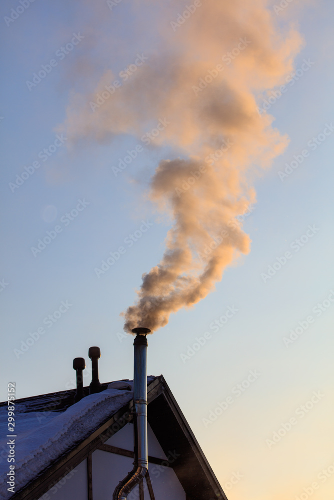 Wall mural Smoke from the chimney of a house at dawn of the sun