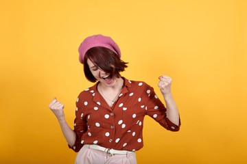 Fototapeta na wymiar Young beautiful brunette woman wearing red shirt looks very happy and excited doing winner gesture with arms raised, laughing, smiling, screaming for success. Celebration concept.